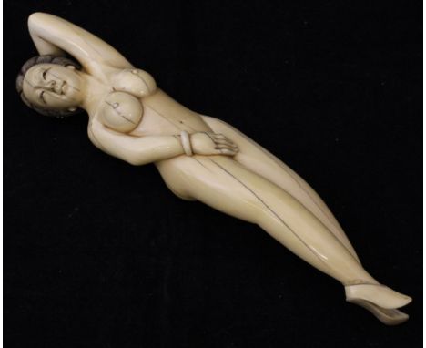 A Japanese Meiji Period carved ivory medical figure as a reclining nude, her left hand behind her head, indistinctly signed t