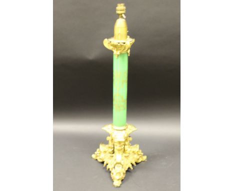 A Victorian gilt brass and milk glass table lamp, the tapering gilt decorated column with gothic style foliate decorated cap 