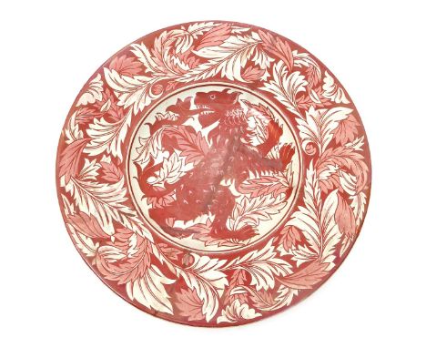 A William De Morgan charger,  painted with a heraldic lion regardant before foliage, the border a frieze of foliage, in ruby 