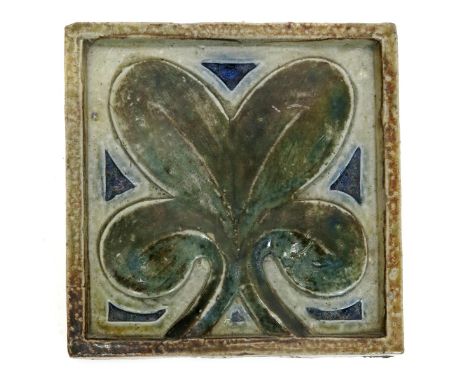 A Martin Brothers stoneware tile by Robert Wallace Martin, square, moulded with a simple leaf design glazed green and blue on