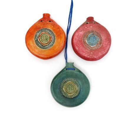 A Compton Potter's Art Guild Pilgrim Bottle flask, cast in low relief with inscribed roundel, glazed green, and two other Com