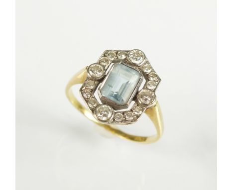 An Art Deco aquamarine and diamond cluster ring, designed as a central trap cut aquamarine collet set within an openwork bord