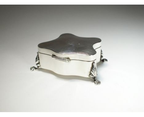 An early 20th century silver mounted trinket box, * H.H, Birmingham 1910, of shaped form with engine turned cover, raised on 