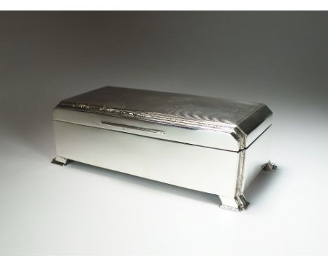 An Art Deco silver mounted cigarette box, *.W, Birmingham 1938, of rectangular form with engine turned canted cover opening t