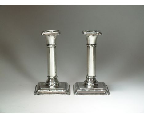 A pair of silver mounted short candlesticks, William Hutton & Sons, Birmingham 1919, each with plain polished stem and raised