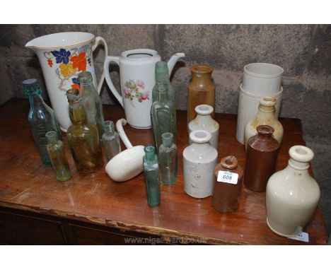 A collection of bottles, stoneware jars, a ladle and a jug, etc.,