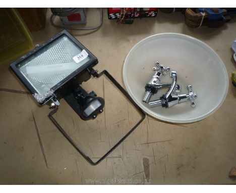 A 10'' plastic bowl containing a pair of new chromium-plated basin taps and a 500 w P.I.R. activated floodlight/security ligh