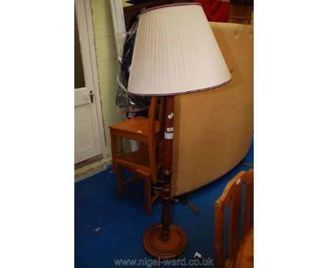 Wooden tapered column standard lamp with shade.