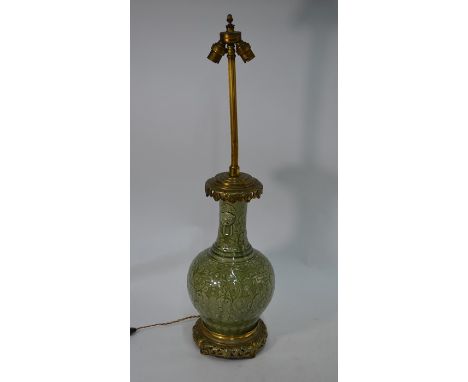 A Chinese porcelain brass mounted table lamp, the celadon glazed body with raised foliate decoration, key fret and ruyi bands