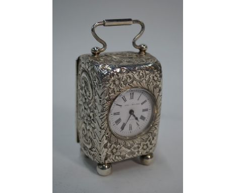 A Victorian silver boudoir clock, the case profusely chased with flowers and foliage, hinged loop top handle, French movement