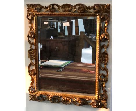 An antique Florentine style giltwood framed bevel edged mirror