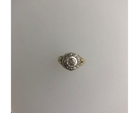 An oval diamond cluster ring, the central diamond in rubover setting with diamonds around, size N, yellow metal set, 4g all i