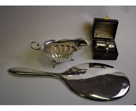 A plain silver hand-mirror, Chester 1930, to/w a sauce-boat, Sheffield 1922 and two napkin rings in leather case (not a pair)