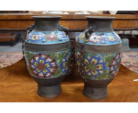 A pair of Chinese 19th century patternated spelter and champleve vases with animal mask handles and polychrome enameled flora