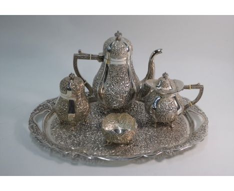 An Indian heavy quality white metal three-piece coffee service, pear-shaped, with richly chased reserves depicting elephant f