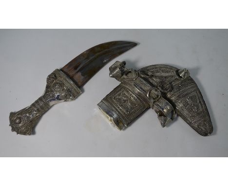 An antique Arab dagger Jambiya, the low-grade silver hilt and scabbard richly decorated with wire filigree and beading, 28cm