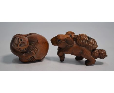 Two 20th century Japanese boxwood netsuke; a macaque crouching on an oversize peach with mother-of-pearl signature tablet , a