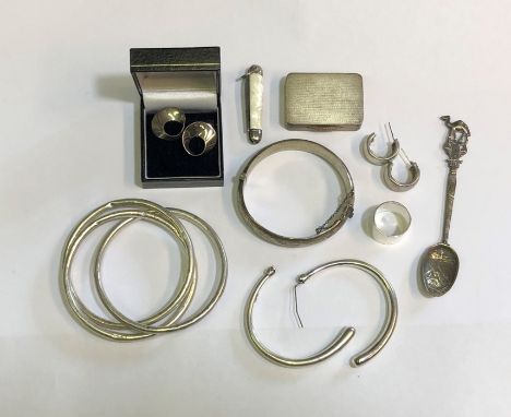 An assortment of silver and white metal jewellery items including half engraved hinged bangle, trio of linked bangles, three 