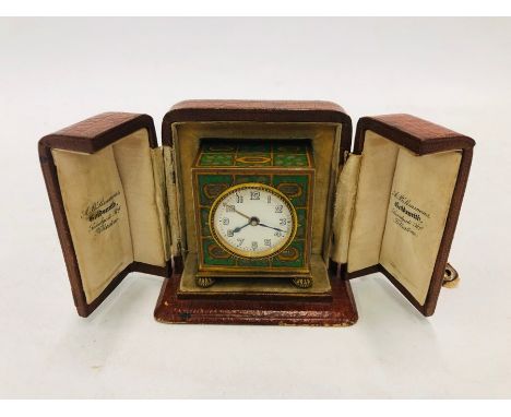 A vintage green enamelled gilt cased miniature travelling alarm clock, in fitted table case, 6 cm h o/a