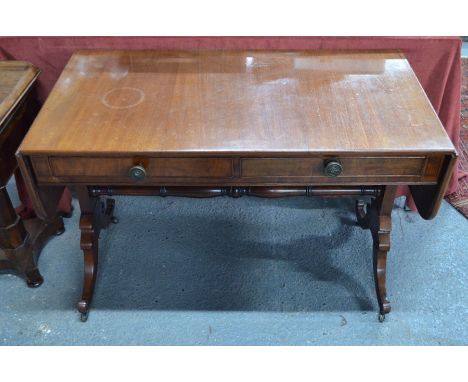 A Victorian mahogany sofa table, with two frieze drawers opposing dummy drawer fronts, raised on trestle ends to scroll feet 