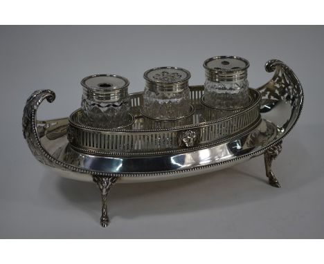A George III silver inkstand of 'navette' form, the curled-over handles chased and pierced as foliage, the oval galleried cen