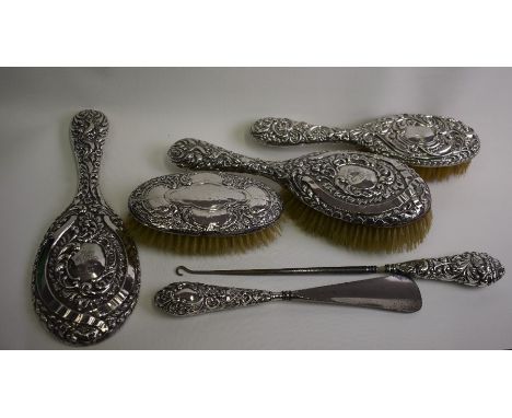 Three silver-backed hairbrushes, a hand-mirror, button-hook and shoe horn (6)