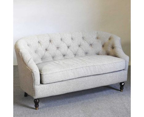 A modern grey upholstered button back sofa, with a curved back, on turned legs145w x 77d x 74h cm