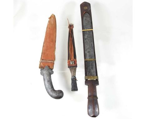 A vintage African dagger, with scabbard, 38cm long overall, together with two Eastern knives (3)