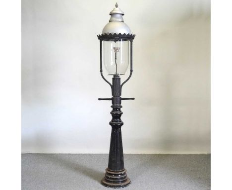 A cast iron lamp post, with a glass shade, 207cm high