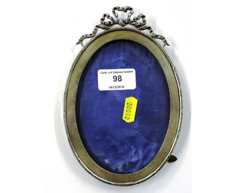 A silver photograph frame with ribbon tied decoration