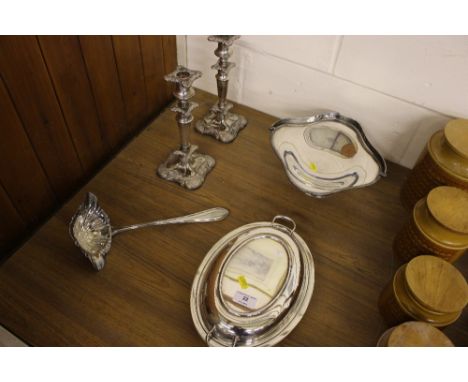 A quantity of silver plated ware to include a pair of candlesticks; a ladle; a swing handled basket and an entree dish