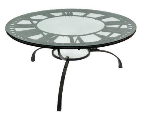 A wrought iron clock face reputedly from Euston Station adapted as a dining table:, with plate glass top, on tripod splayed s