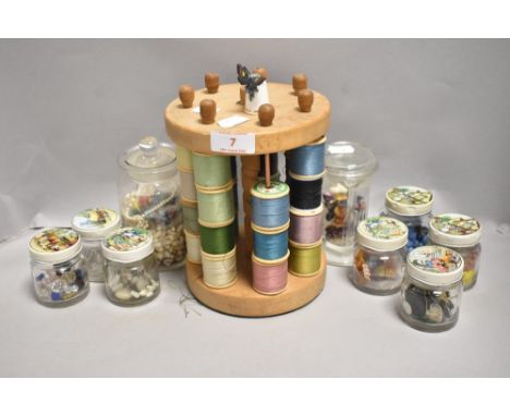 A 20th century cotton bobbin holder with a selection of glass and similar beads