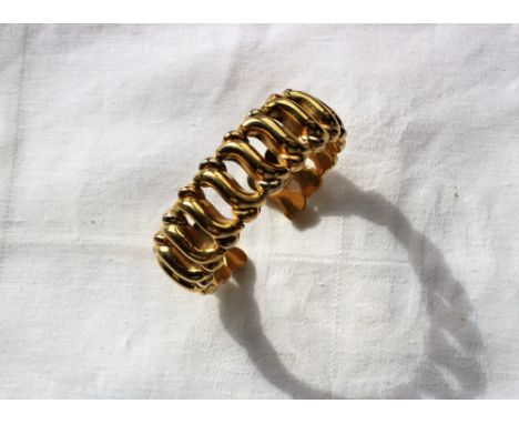 An 18ct yellow gold bangle with scrolling links, approximately 39 grams