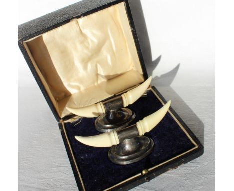 A pair of George V silver and ivory knife rests, in the form of horns on an oval base, loaded, Birmingham, 1938, cased CONDIT