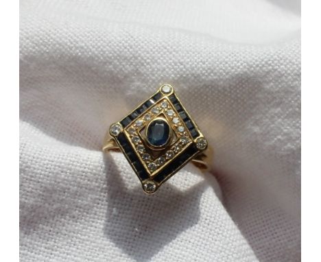 A sapphire and diamond ring, in the Art Deco style set with a central oval faceted sapphire surrounded by sixteen round brill