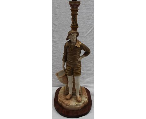 A Royal Worcester porcelain "Cricklite" blush ivory lamp base of a gentleman holding a basket leaning up against a lamp post 