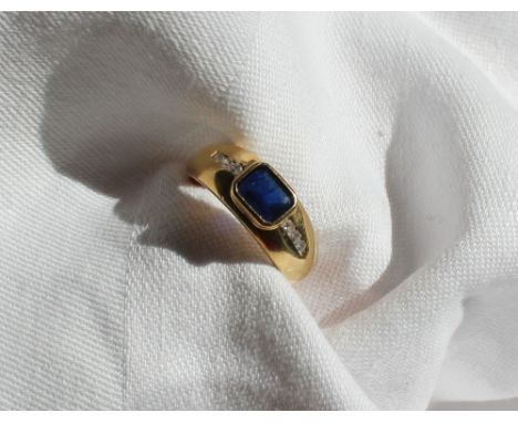 A sapphire and diamond ring, the central emerald cut sapphire approximately 6.5 x 4.5mm, each shoulder set with three round b