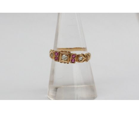 An 18ct yellow gold ruby and diamond ring, set with a central round old cut diamond, flanked by a pair of rubies and two furt