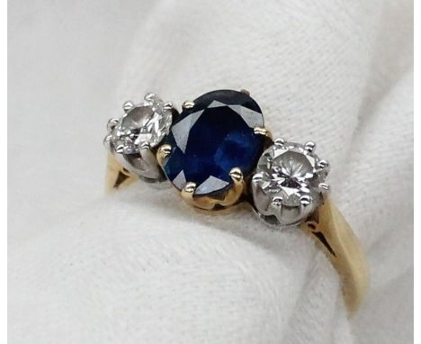 A sapphire and diamond ring, the central oval sapphire measuring approximately 9mm x 7mm flanked by two round brilliant cut d