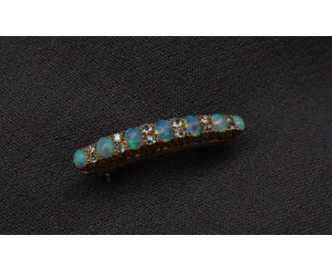 An opal and diamond bar brooch, set with seven cabochon opals and twelve round old cut diamonds to a yellow metal claw settin