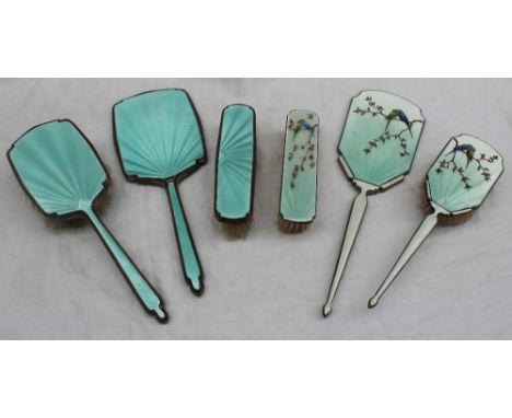 An Elizabeth II silver and enamel decorated part dressing table set, comprising a hand mirror, hair brush and clothes brush d