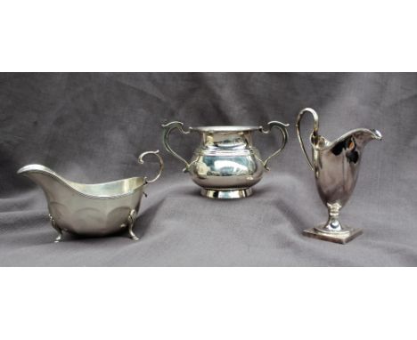 A George V silver twin handled sugar basin, London, 1939, together with a silver helmet shaped cream jug and a silver sauce b