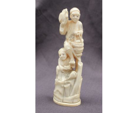 A 19th century ivory figure group depicting a figure holding a hen in his right hand and basket in his left, being held aloft