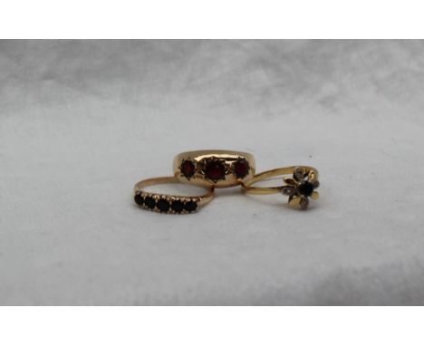 A 9ct gold garnet set gypsy ring, together with an 18ct gold sapphire and diamond ring and a 9ct gold sapphire set ring