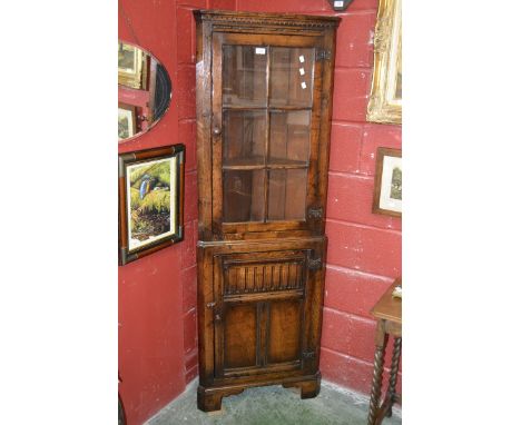 A Titchmarsh and Goodwin oak floor standing corner cupboard, glazed panel door to top