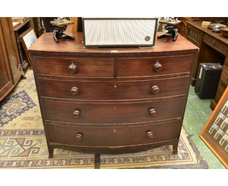 An early 19th century mahogany bow front chest, two short cockbeaded drawers over three graduated long, button handles, sprea