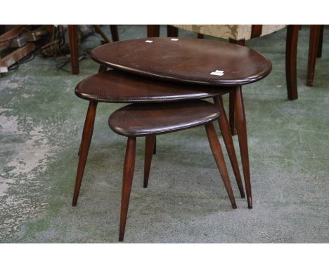 An Ercol nest of three three legged tables.