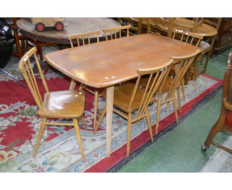 An Ercol dining table and six spindle back chairs.