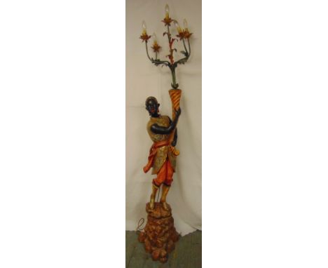 A late 19th early 20th century polychromatic carved wooden Blackamoor supporting a five branch candelabra floor lamp